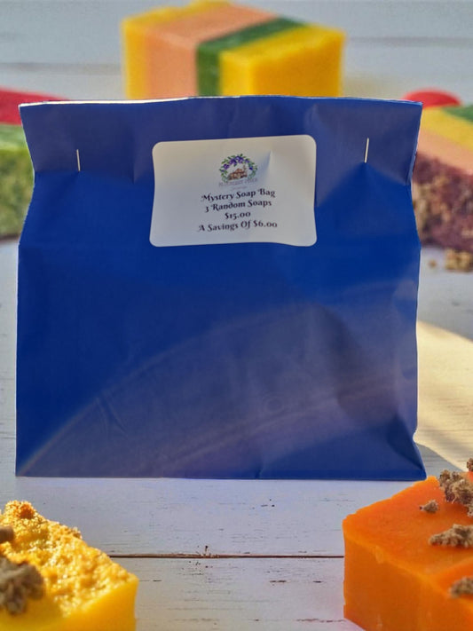 Blue mystery soap bag with a label in front of various soaps on a wooden surface